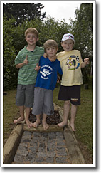 Drei Kinder posieren auf dem neuen Barfuß-Parcours beim Sommerfest 2006